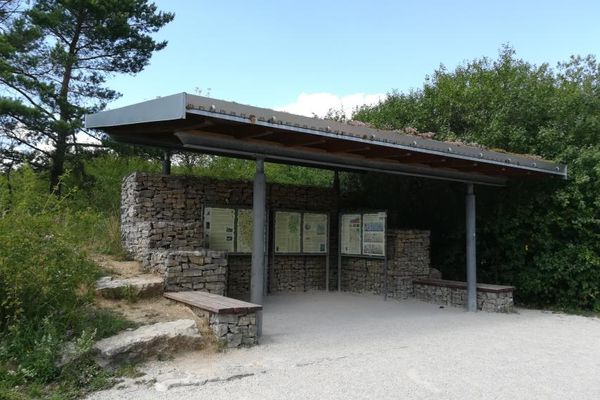 Ein nach vorne offener, überdachter Pavillon, an dessen Wänden Infotafeln angebracht sind.