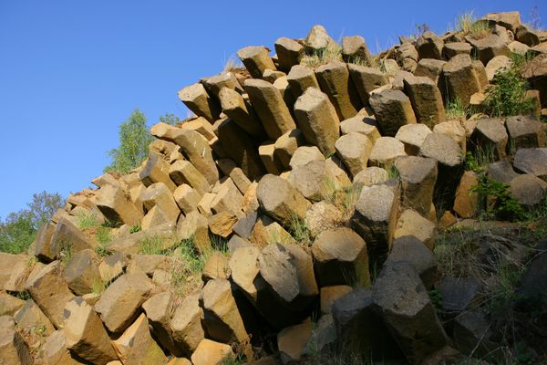 Meterhoch türmt sich Säulenbasalt an der Abbruchkante des Steinbruchs.