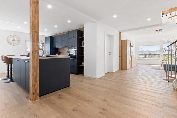 Wohn-Essbereich der Ferienwohnung Bergfeld mit einer schwarzen Küche