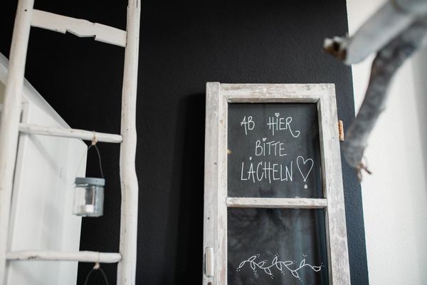 Ab hier bitte Lächeln auf einem kleinen Schild stehend