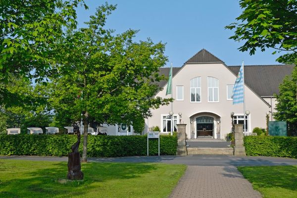 Auf dem Bild ist der Eingangsbereich (außen) des Golfhotels zu sehen.