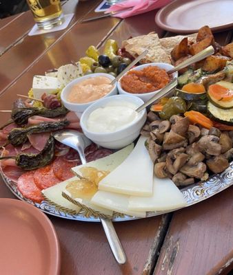 Auf dem Bild sieht man eine Tapasplatte mit Saucen, Käse, Fleisch und Gemüse.