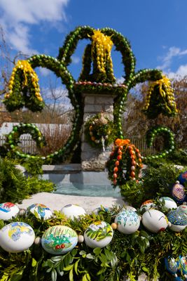 Bunt geschmückter Osterbrunnen mit Girlanden.