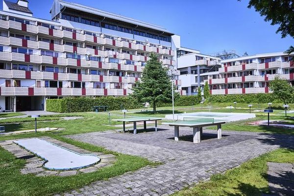 Hotelanlage mit vielen weiß-roten Balkonen. Im teils schattigen Innenhof befinden sich Tischtennisplatten und eine Minigolfanlage.