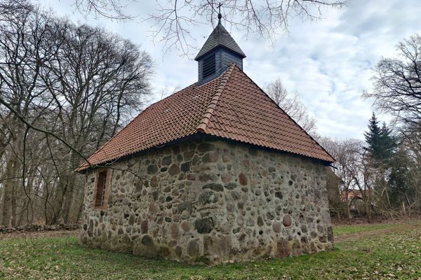 Rückseite der kleinen, rechteckigen Felsteinkapelle in Müssingen mit rotem Ziegeldach und kleinem hölzernen Dachreiter