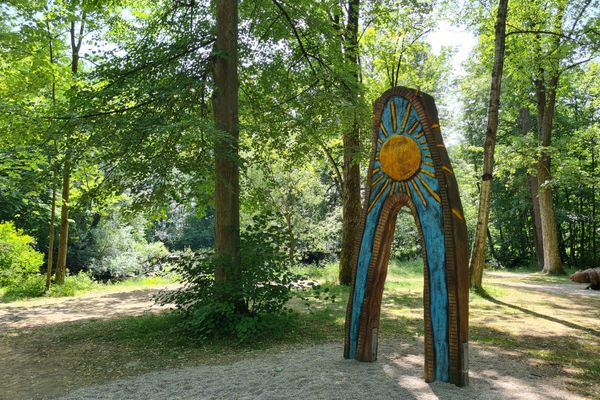Das Bild zeigt einen Ausschnitt der Fantasiewelten in Mitwitz. Man sieht eine Sonne aus Holz geschnitzt.