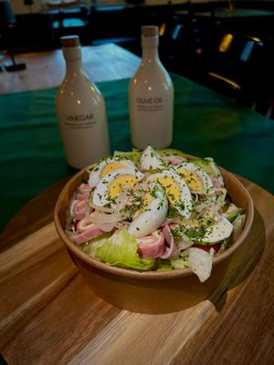 Das Foto zeigt einen typisch frischen italienischen Salat mit Ei und verschiedenen Ölen.