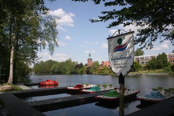 Tretboote am See im Kurpark Bad Bodenteich mit Blick auf die Kirche im Hintergrund.