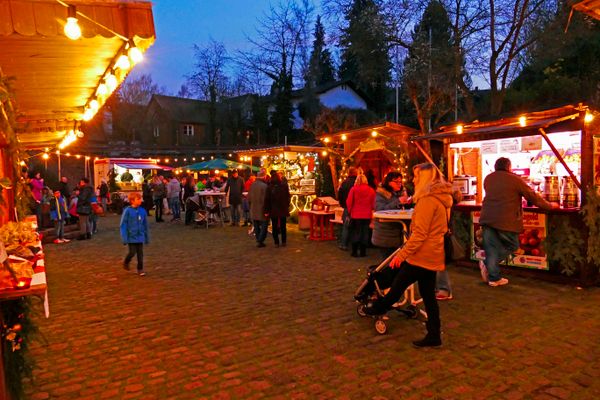 Im Innenhof der Rentmeisterei in Bad König stehen anlässlich des Nikolausmarktes bunt beleuchtete Weihnachtsmarktbuden.
