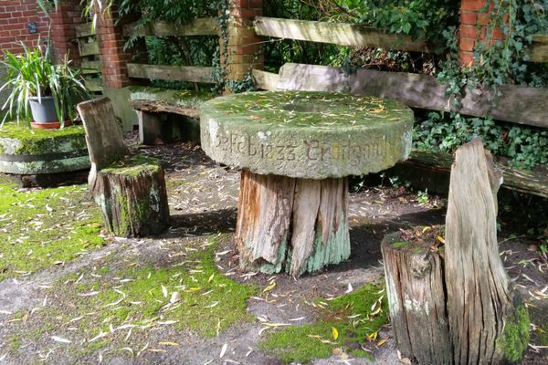 Rastplatz bei der Kroetzmühle mit Sitzgelegenheiten aus Holz und einem Tisch aus einem historischen Mühlstein.