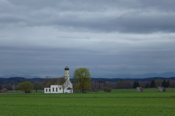 Traumhafter Blick auf die Kapelle St. Johann vor der majestätischen Alpenkette.