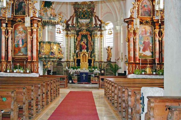 Barocker Kircheninnenraum mit Hauptaltar unter einer Gewölbedecke, zwei Seitenaltären, Kanzel und Bankreihen.