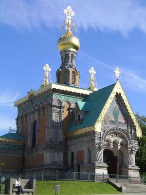 Russisch-orthodoxe Kapelle mit goldener Kuppel, verzierten Fassaden und Mosaik über dem Eingang bei blauem Himmel