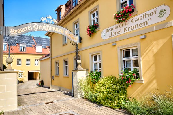 Seitlicher Blick auf das Gasthaus mit gelber fassade.