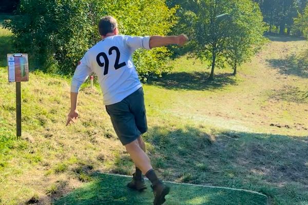 Ein Mann wirft die Discgolfscheibe