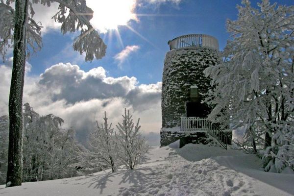 Der Hirschenstein-Aussichtsturm steht tief verschneit inmitten einer herrlichen Winterlandschaft. Strahlender Sonnenschein lässt den Schnee glitzern