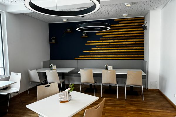 Auf dem Bild ist der Innenraum des Museumscafés zu sehen. Hier stehen mehrere Stühle und Tische.