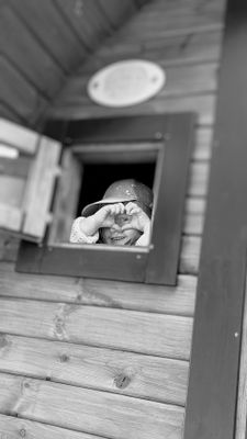 Auf dem Bild ist ein Kind am Fenster der Fass-Sauna zu sehen.