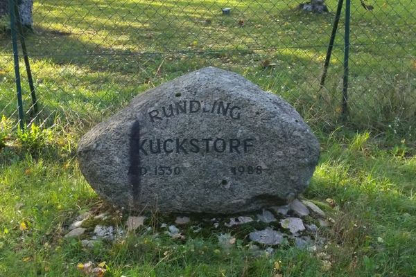 Gedenkstein im Ortsteil Kuckstorf mit eingraviertem Ortsnamen und Jahreszahlen, aufgestellt in einer Grünanlage.
