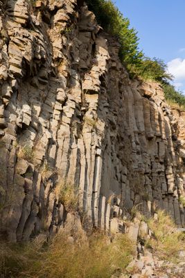 Meterhoch türmt sich Säulenbasalt an der Abbruchkante des Steinbruchs.