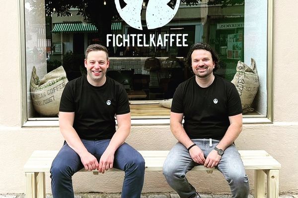 Auf dem Bild sind die beiden Gründer Micha und Simon vor dem Fichtelkaffee sitzend zu sehen.
