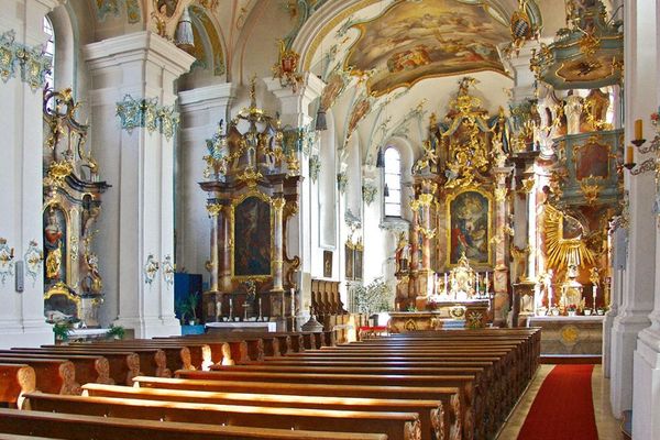 Barocker, reich verzierter Kircheninnenraum mit Hauptaltar, Seitenaltären, Kanzel, Gewölbedecke, Deckengemälde und Bankreihen.