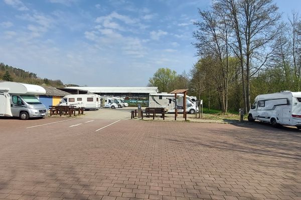 Wohnmobilstellplatz Mosbach mit einigen Wohnmobilen und einer Sitzgelegenheit mit Rad- und Wanderkarte um Mosbach