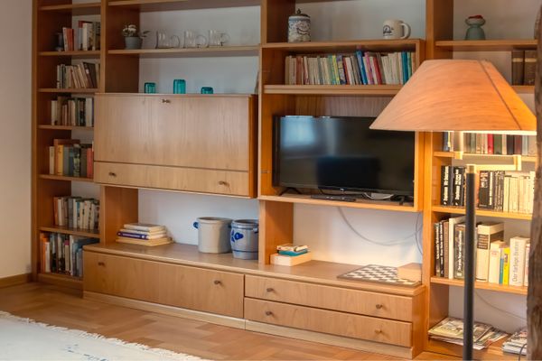 Regalwand mit Büchern, integriertem Fernseher und Lampe im Wohnzimmer.