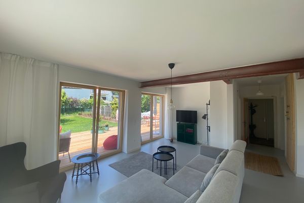 Blick in den Wohnbereich mit gemütlicher Couch und Zugang zur Terrasse